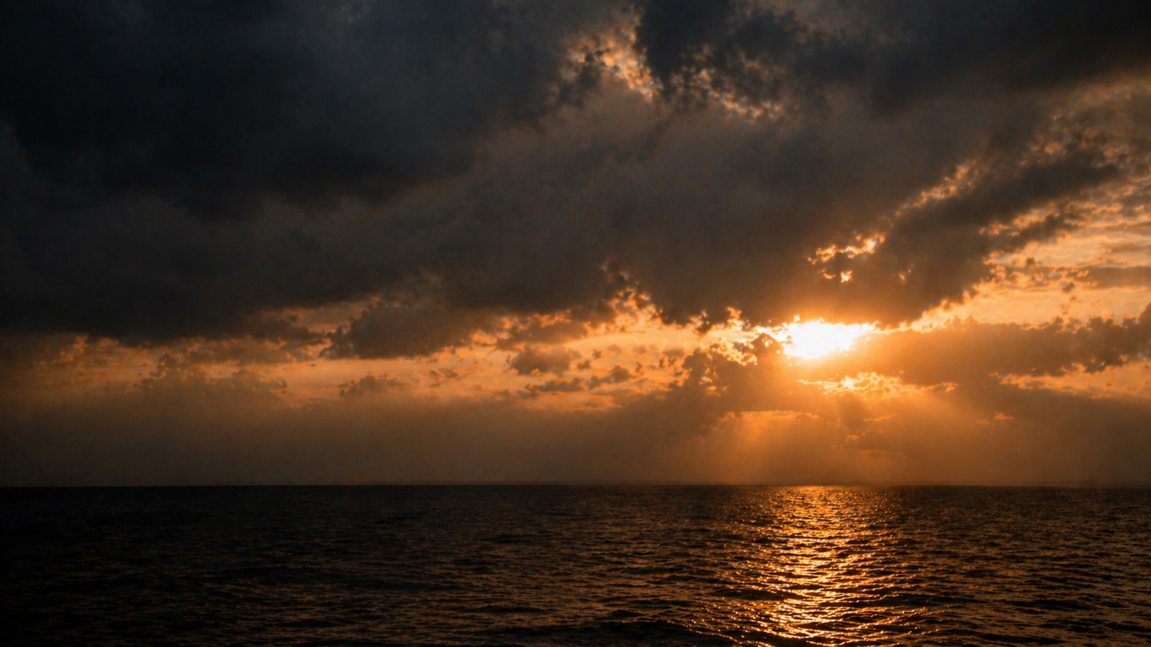 Sunrise breaking through dark clouds, light overcoming darkness